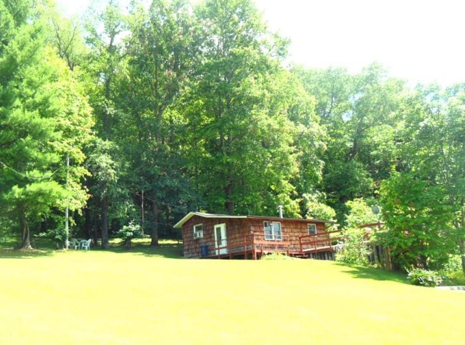 Summer view of this cozy cabin by the woods. Rural, yet so near to attractions.