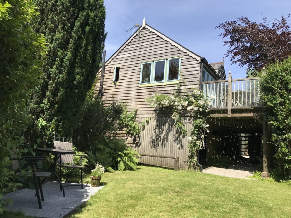 Looking up at the Boathouse from the garden, with small patio area outside