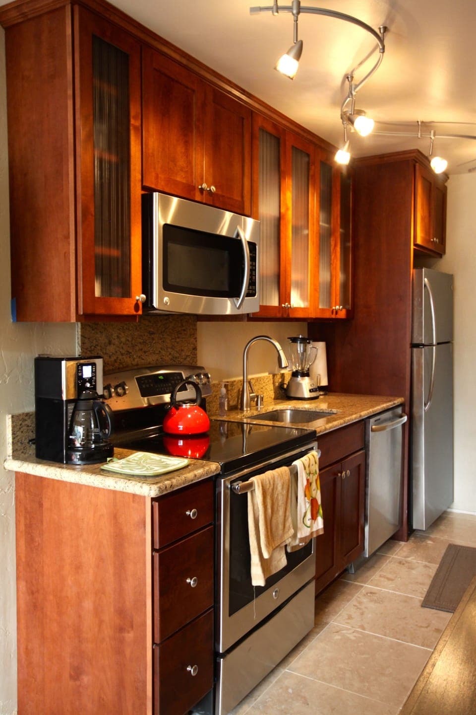 The brand new kitchen has stainless steel appliances.