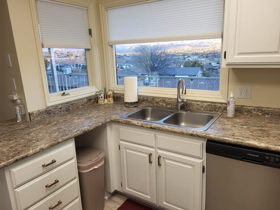 Kitchen has lovely views toward Snow Canyon; recycling bin behind garbage can