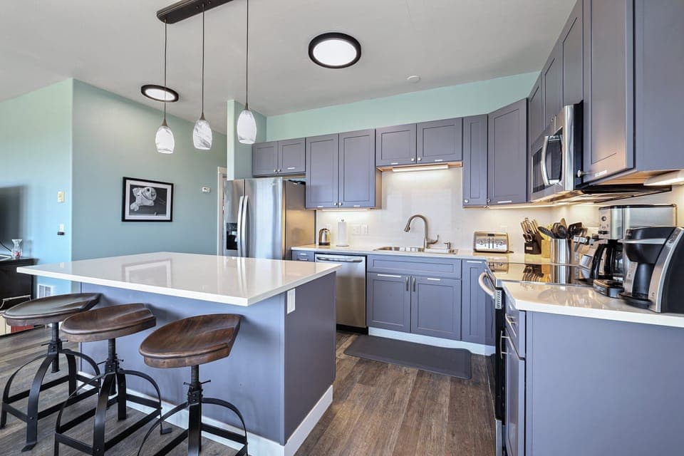 Updated modern kitchen with 3 bar stools at the island.