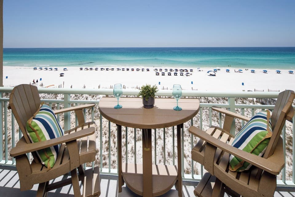 IT'S ALL ABOUT THE VIEW - BAR HEIGHT CHAIRS AND TABLE LET YOU LOOK OVER THE RAILING AT THE STUNNING GULF AND BEACH SERVICE. FOUR EXTRA CHAIRS IN CORNER.