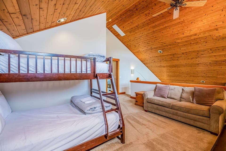 Family-friendly loft with cozy bunk beds, vaulted pine ceilings, and plush lounging space