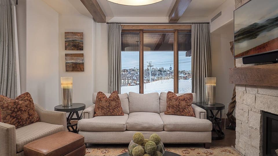 Unwind in your elegant living room with exposed beams and a crackling fireplace while enjoying breathtaking mountain views from your window.