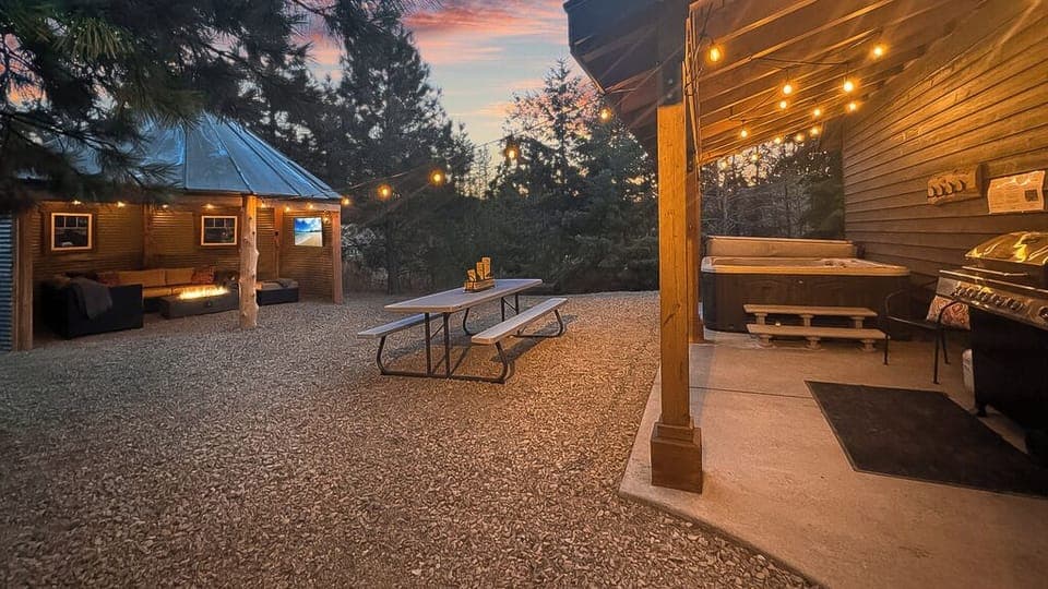 Step into a private backyard with hot tub, fire-lit pavilion, and picnic dining