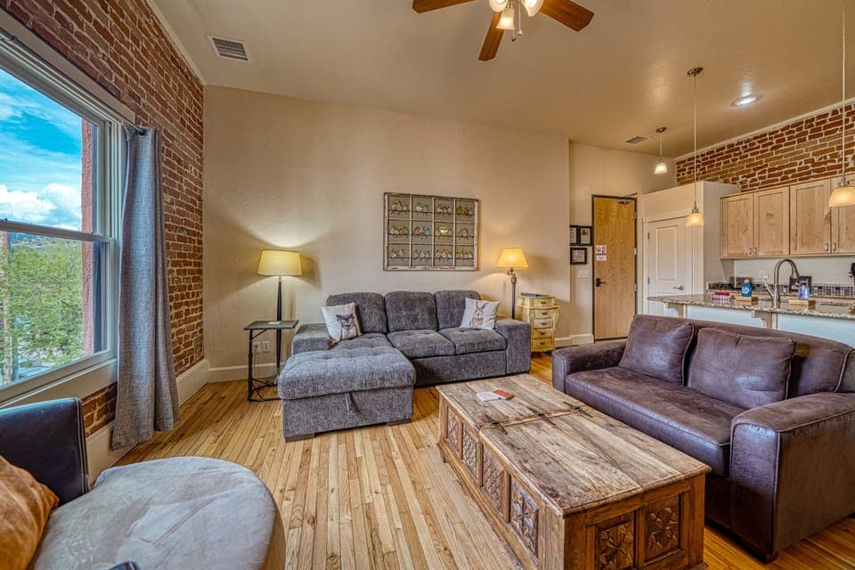 Exposed brick and high ceiling complement this spacious room to hang out and relax in