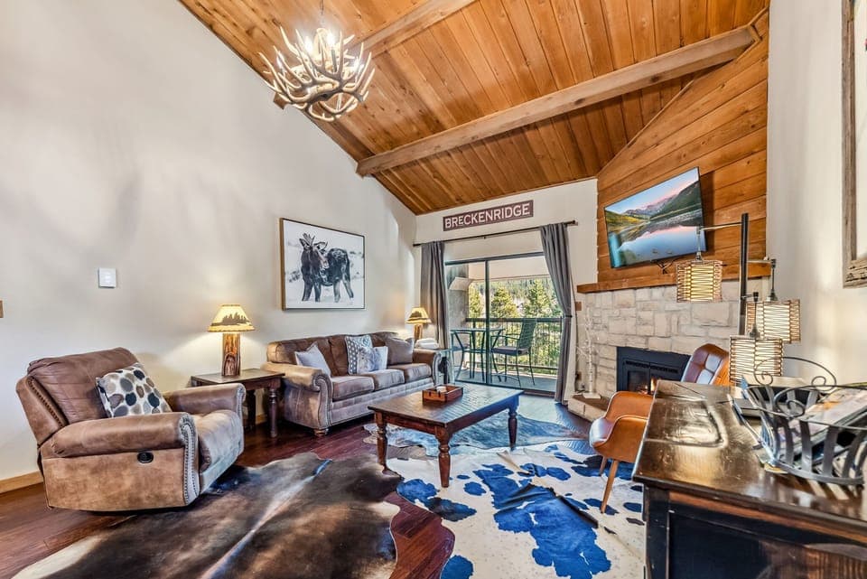 Living Room: Couch, 2 chairs, gas fireplace, Smart TV, access to balcony, open layout to kitchen 
