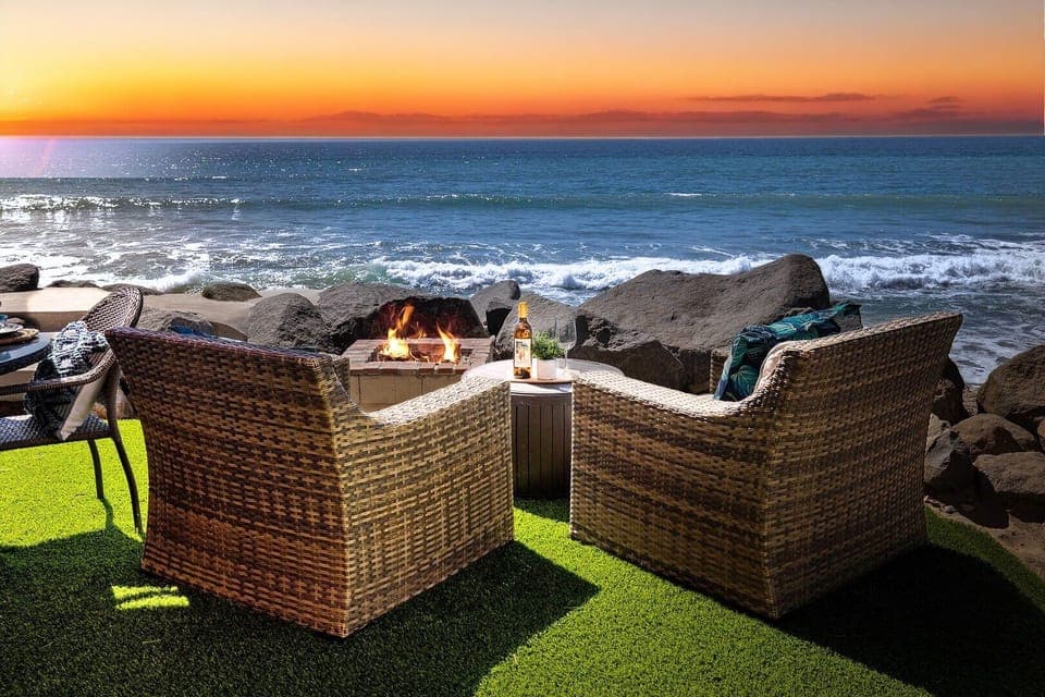 Beachfront fire pit seating creates the perfect oceanside retreat for evening gatherings with stunning sunset views.