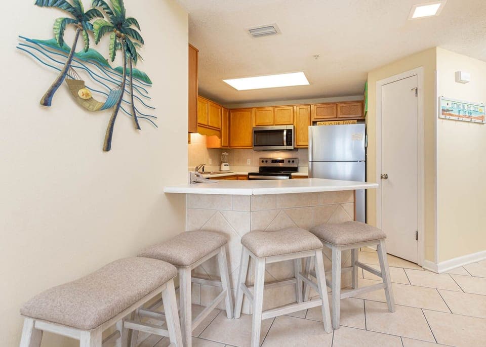 Gather around the breakfast bar, enjoying a casual meal while admiring the beach-themed decor and kitchen amenities