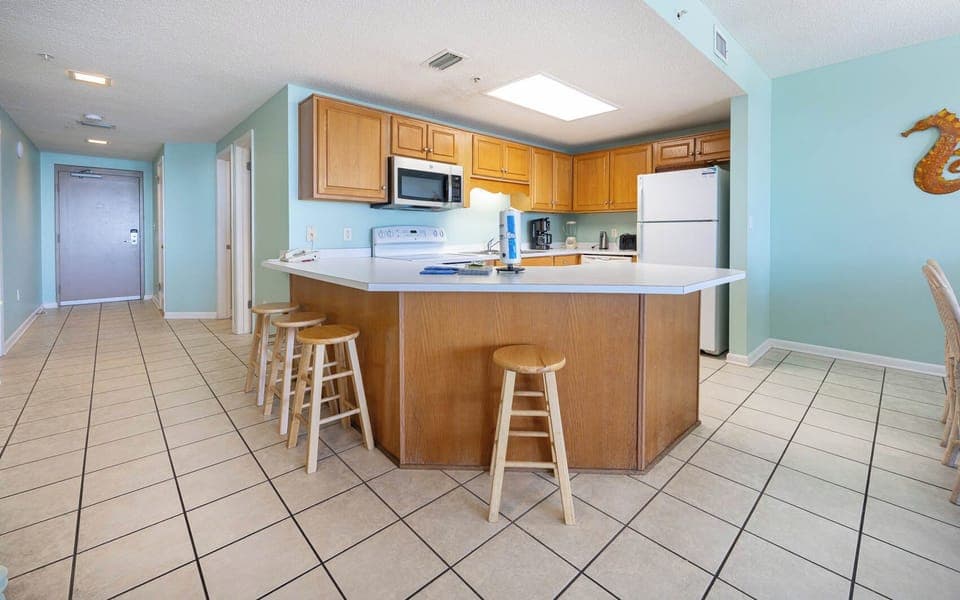 Gather around the spacious kitchen bar with seating, perfect for enjoying meals and conversations in a welcoming space