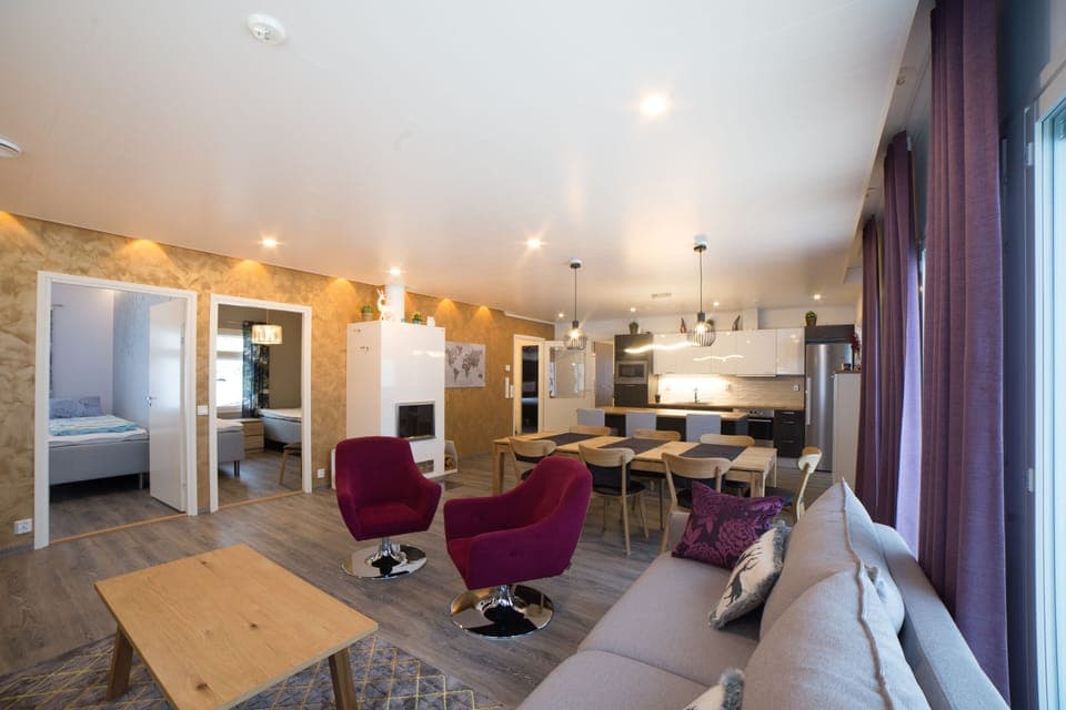 open concept living room kitchen dining area with fireplace and lake view