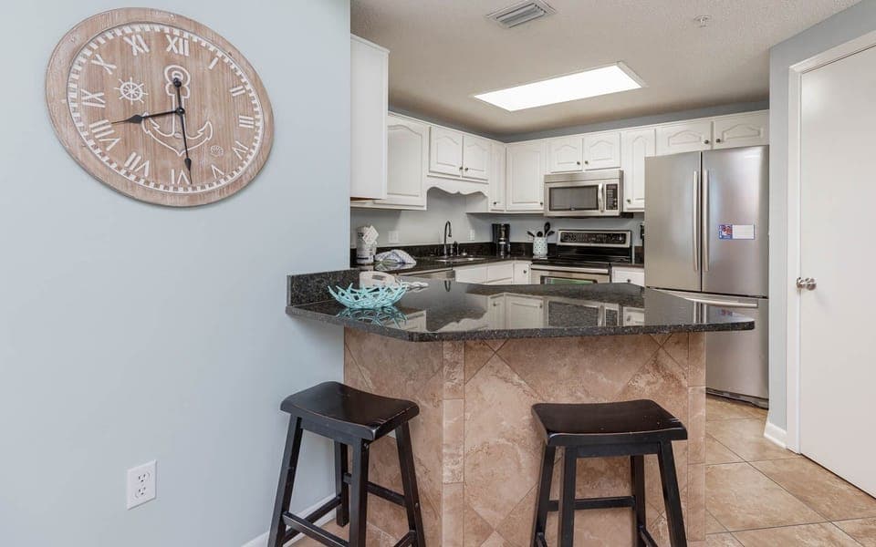 Gather around the stylish bar area with sleek stools, perfect for casual meals and conversations in the inviting kitchen