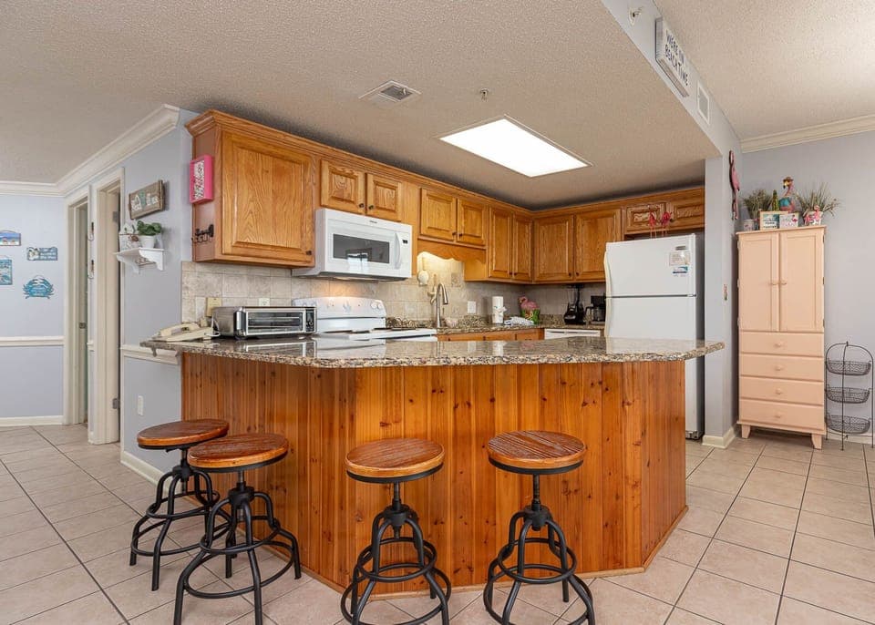 Prepare meals with ease in this inviting kitchen featuring a spacious granite countertop and stylish seating