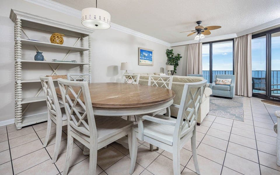 Gather around the round dining table, surrounded by coastal decor and a view that invites relaxation and connection