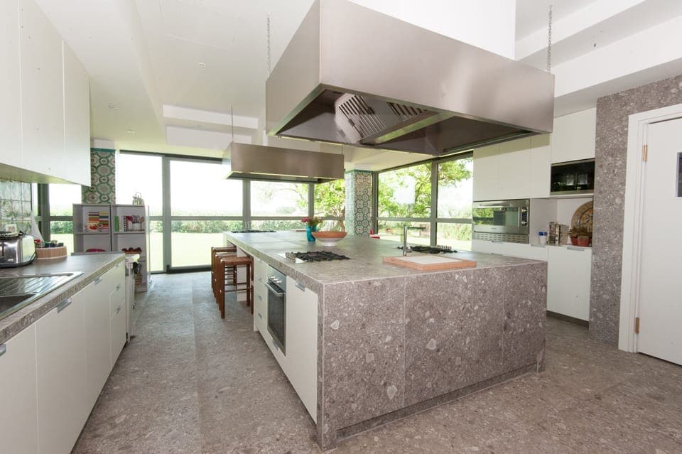 Kitchen with multiple cook stations (3 stoves, 4 refrigerators).