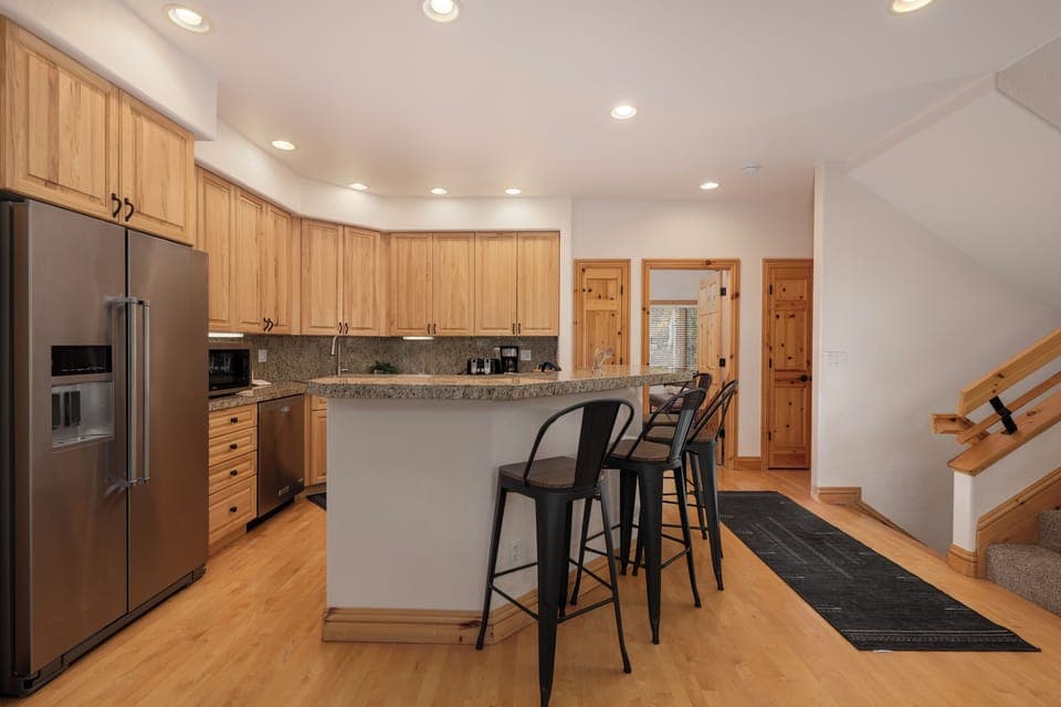 Your gourmet kitchen awaits with granite counters, stainless appliances, and cozy breakfast bar seating for morning coffee conversations.