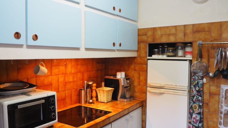 Kitchen with bench-top oven, hotplates, coffee machine and refrigerator