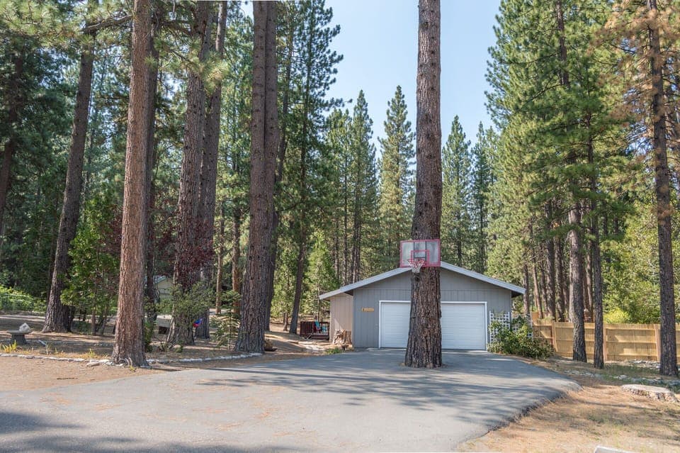 Front of the property featuring large driveway and basketball hoop
