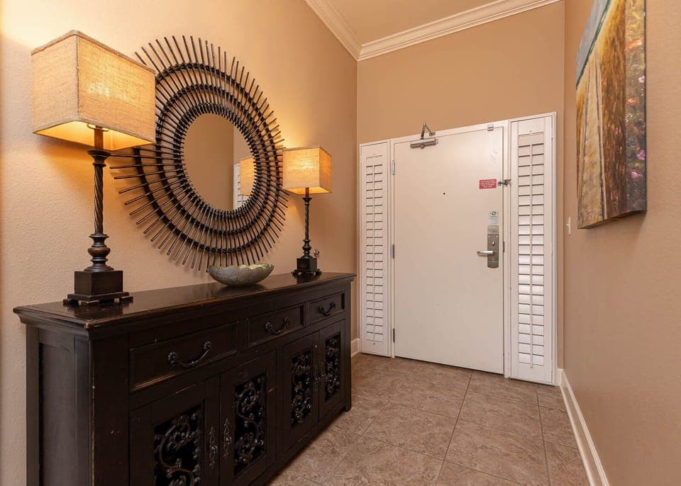 This welcoming entryway features stylish lamps, a decorative mirror, and a sleek console, setting a warm tone for your stay