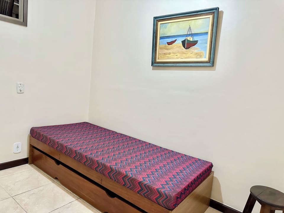 quarto com cama de solteiro e cama auxiliar e ventilador de teto