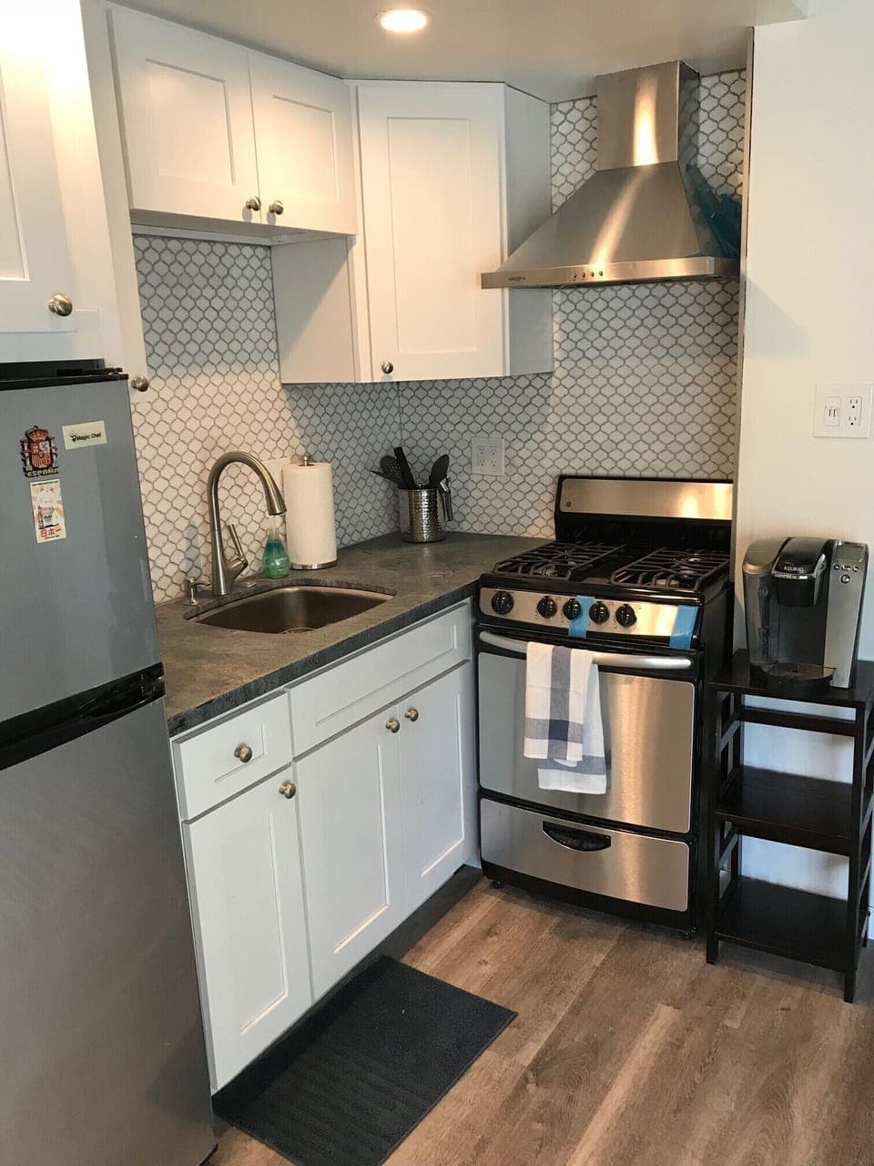 Remodeled Kitchen with fridge, stove, oven, microwave, and cooking supplies.