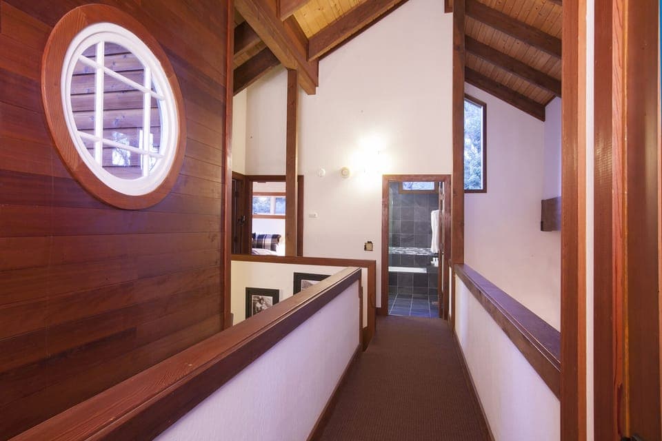 Cathedral ceiling, wood beams and paneling bring in the warmth of this luxury home. At the end of the hallway is a private entrance to the 2nd Master Ensuite bedroom. At the other end of the hallway is a full guest bathroom, a guest bedroom with a qu