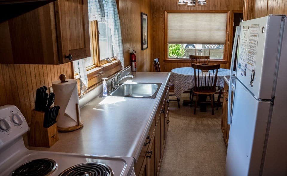 Galley kitchen with full sized appliances including a coffee maker and microwave
