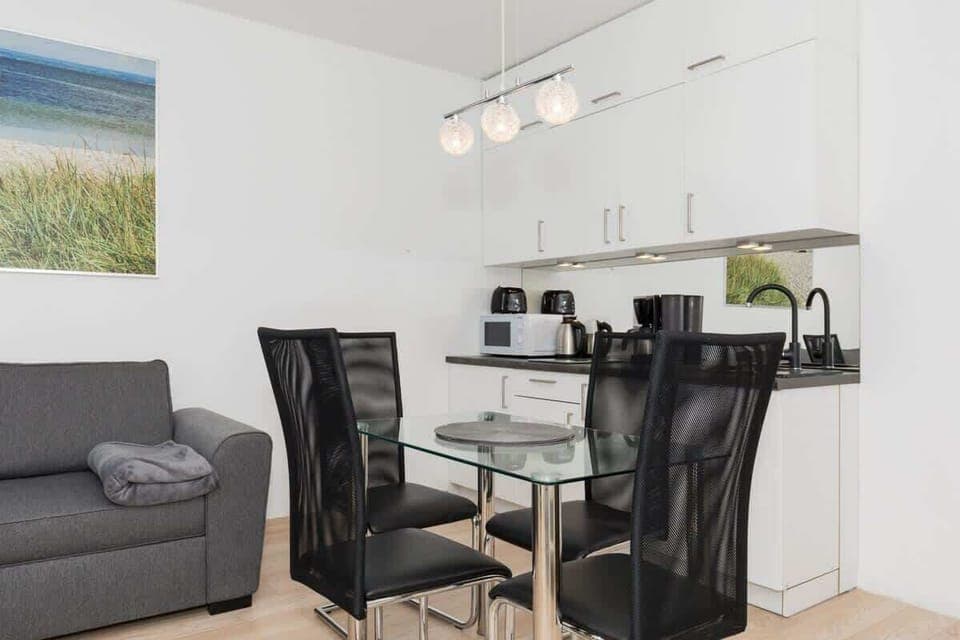 Spacious and bright living room with kitchenette, dining area and elegant double sofa bed.