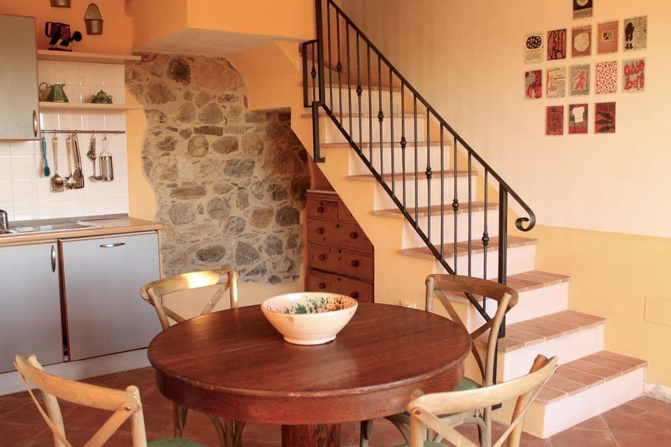 Kitchen and wrought iron stair case with pine chest under nook

