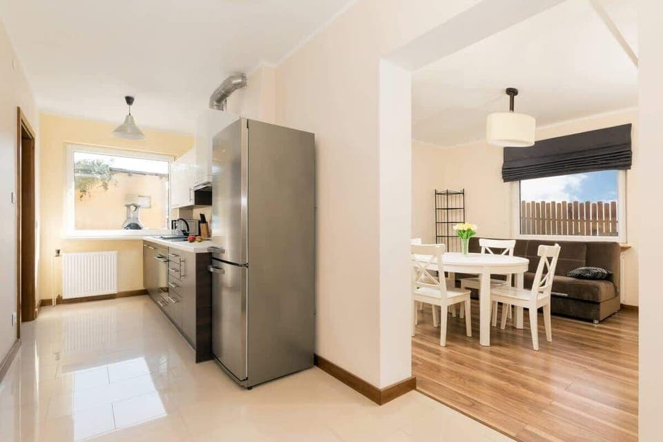 Kitchen area with large fridge with freezer next to visible dining area. 
