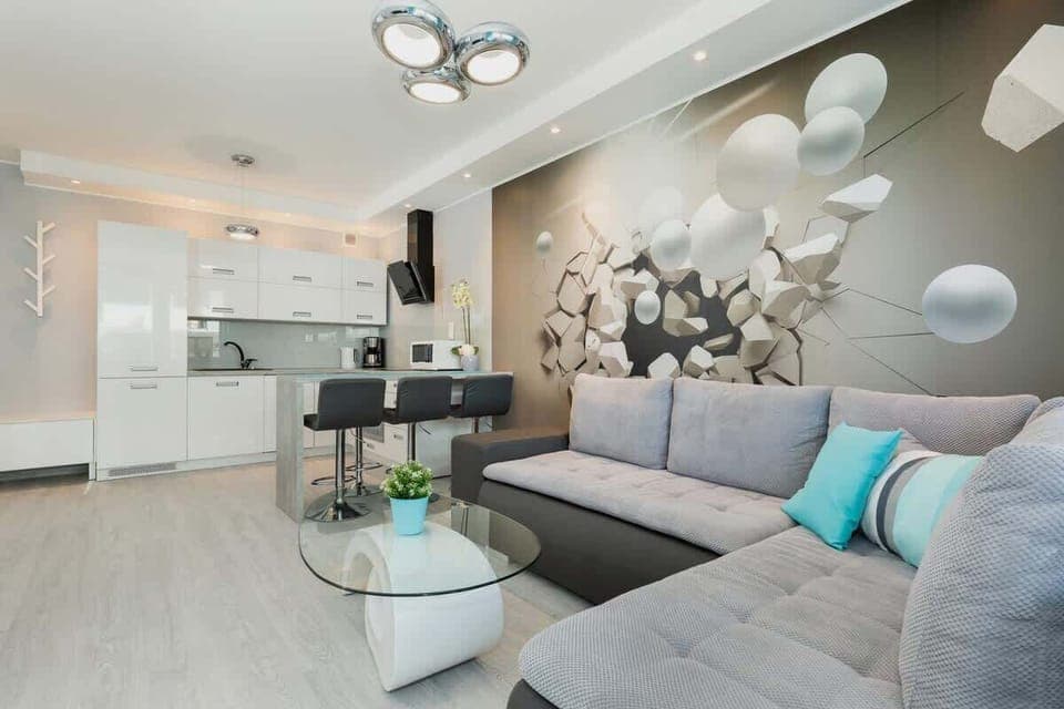 A spacious living room with a sectional sofa, decorative wall panels, and a modern coffee table, arranged in a stylish and inviting layout.