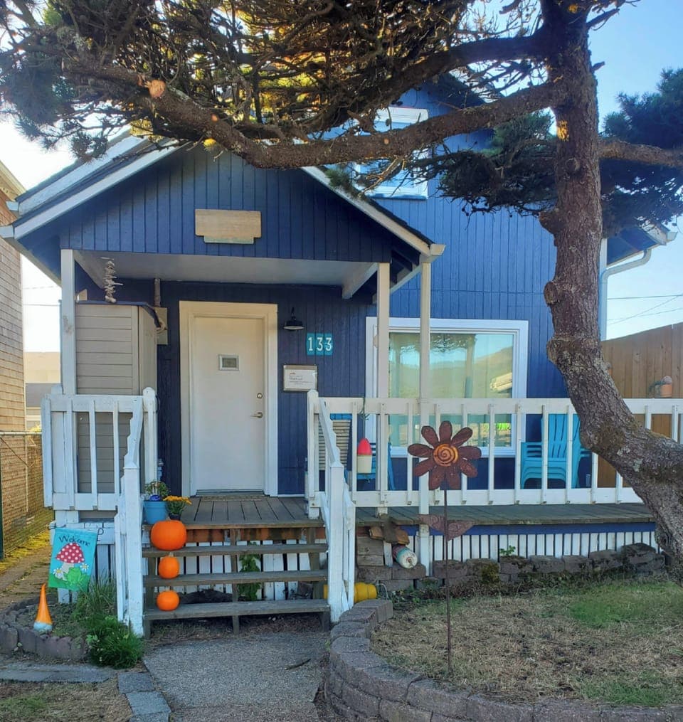 Front of house with fully fenced yard for kids & pups to play in & sunny deck.