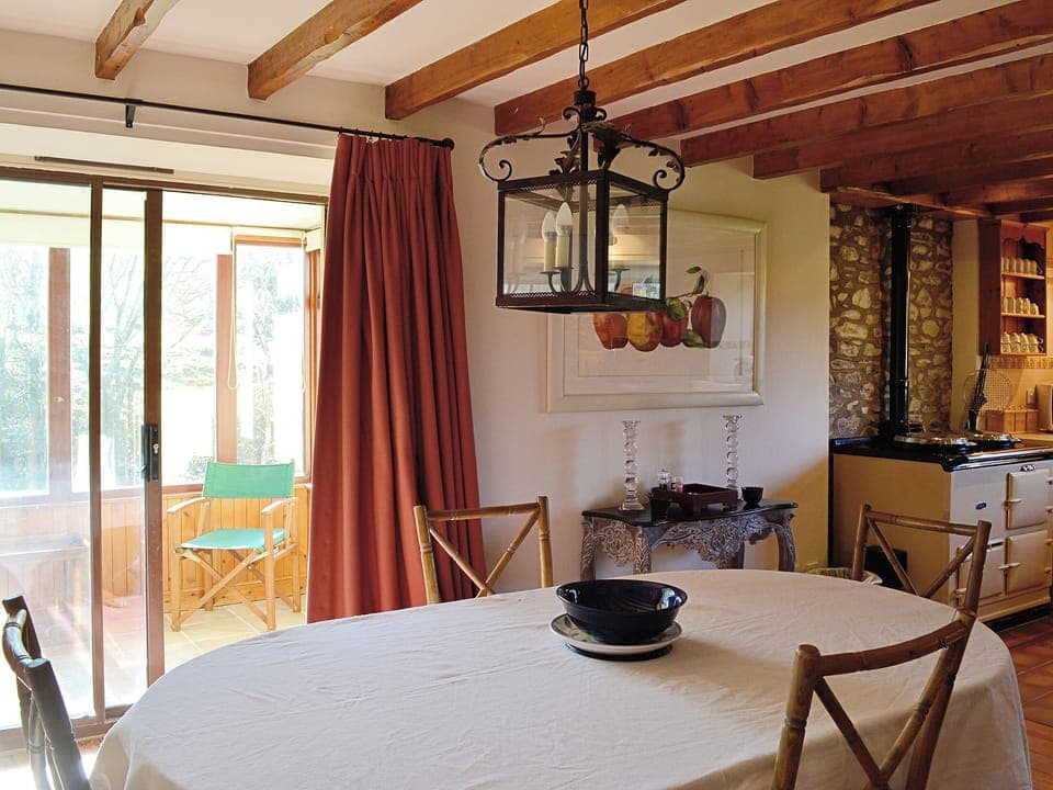 The large dining table is situated alongside the sun room to take advantage of the sunshine | Arkland Mill - Crofts Cottages, Near Castle Douglas