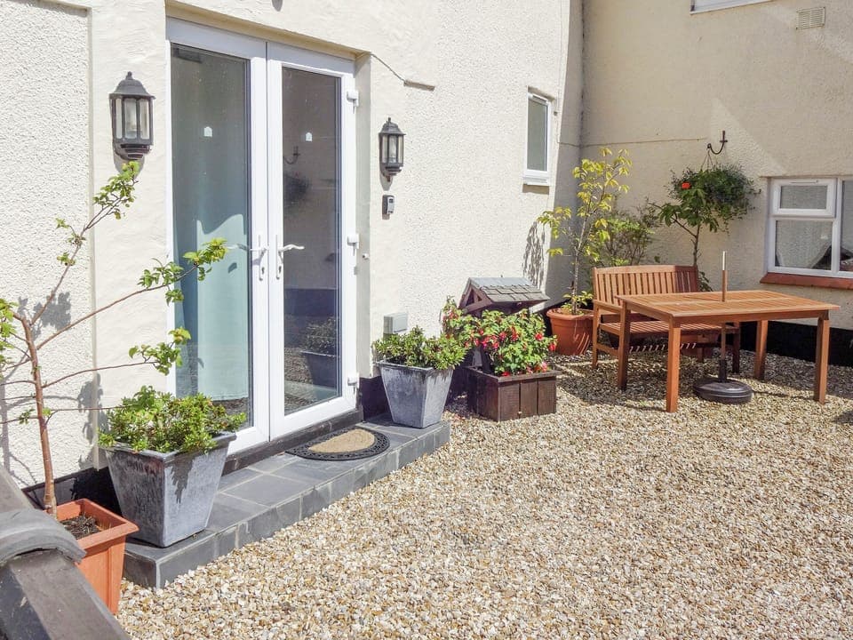 Gravelled courtyard with outdoor furniture | The Snug - Ty Copr, Pen-y-Sarn, near Amlwch