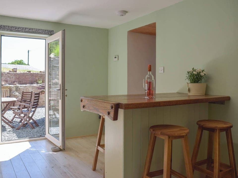Spacious kitchen with breakfast bar and access to the garden | Woodlands, Laugharne, near Pendine