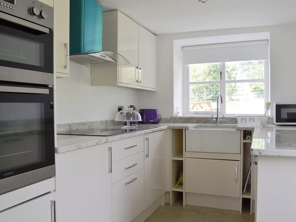 Well equipped kitchen with granite worktops | The Mill Farmhouse (Ty Fferm Y Felin), Llandybie, near Llandeilo