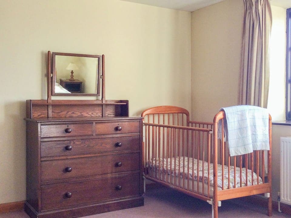 Twin bedroom with children&rsquo;s cot | The Pump House, Hawkesbury Upton
