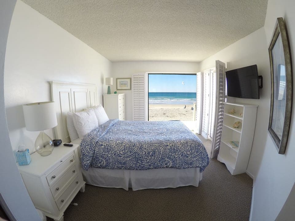 Master Bedroom overlooking ocean   with blue print bedspread