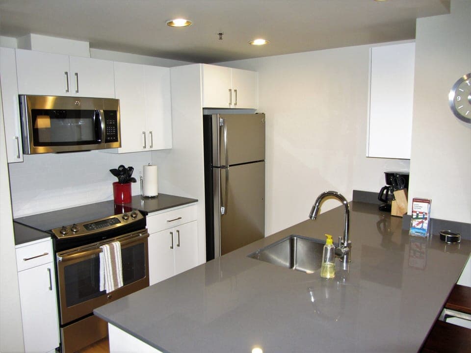 Full kitchen with stainless appliances and gray quartz countertops