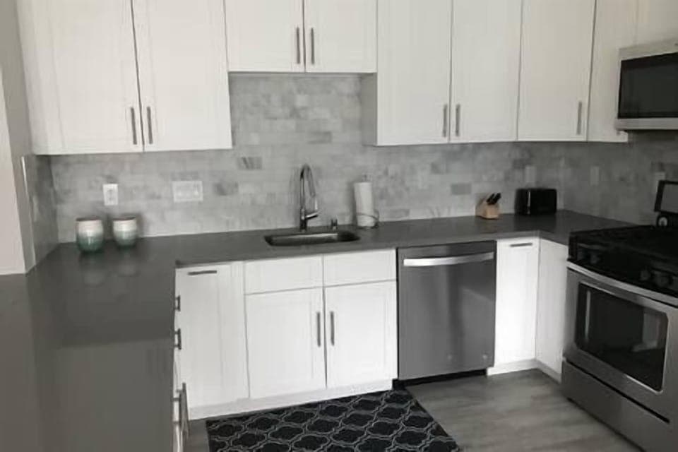 Fully-stocked kitchen with gas stove, oven, microwave, dishwasher, and Keurig, perfect for cooking.