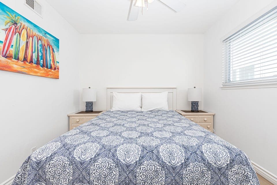 Second bedroom outfitted with Queen bed, linens, ceiling fan, carpeting and closet. Located along central hallway.
                