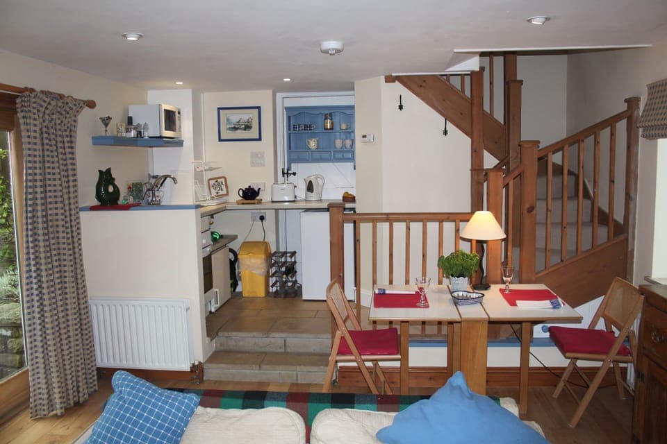 Galley kitchen with fridge, two zone hob, oven, small freezer and storage space.
