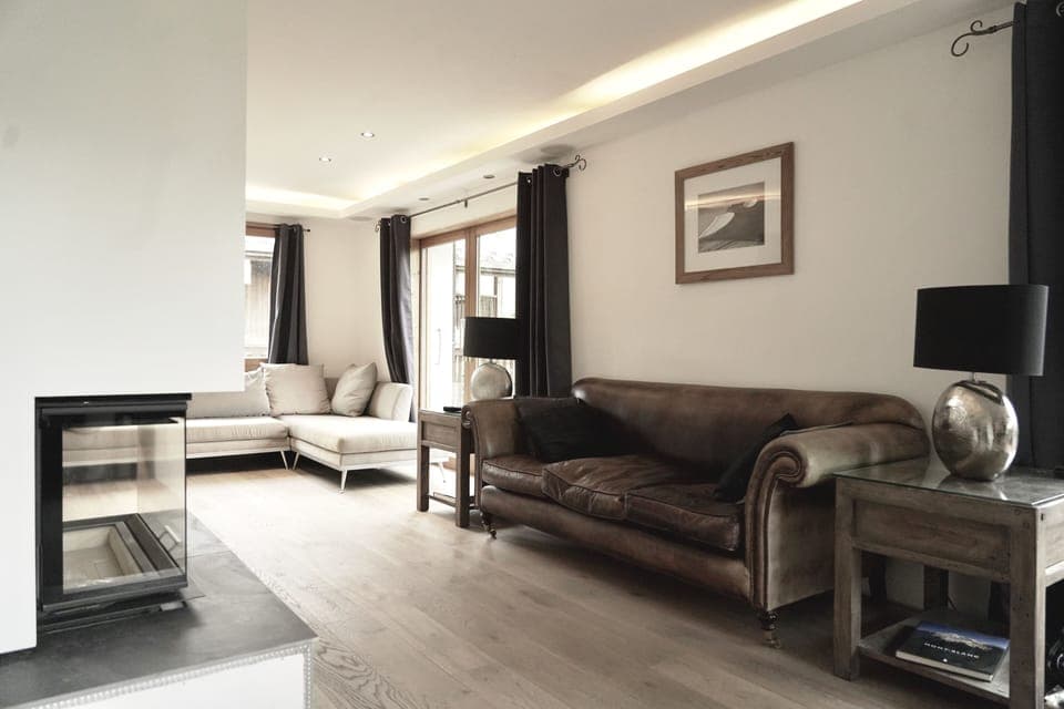 Open plan sitting room with oak floor, wood stove and underfloor heating