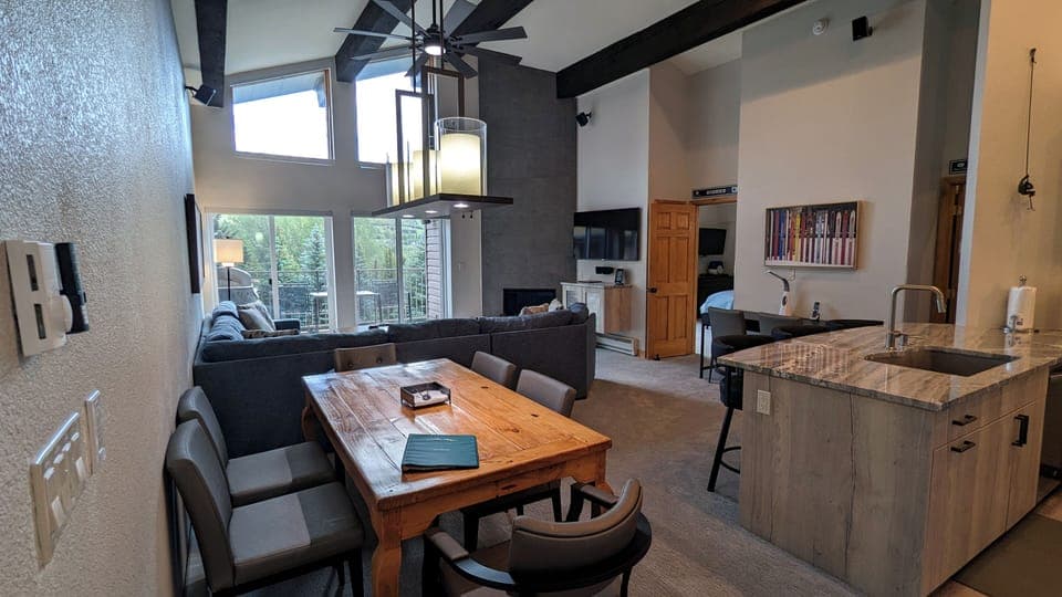 Living room with gas fireplace, dining table, and balcony w/ propane BBQ grill