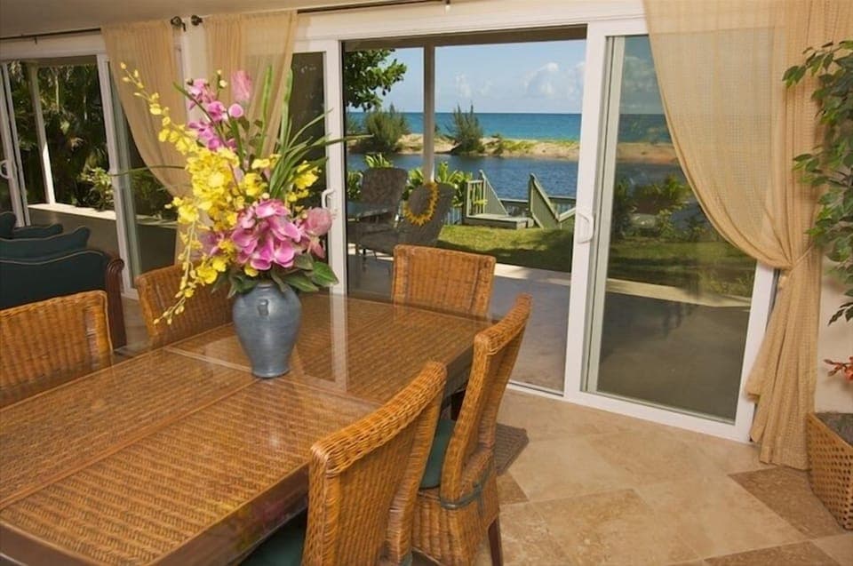 Elegant dining table overlooking the lanai, backyard,  ocean, beach, river