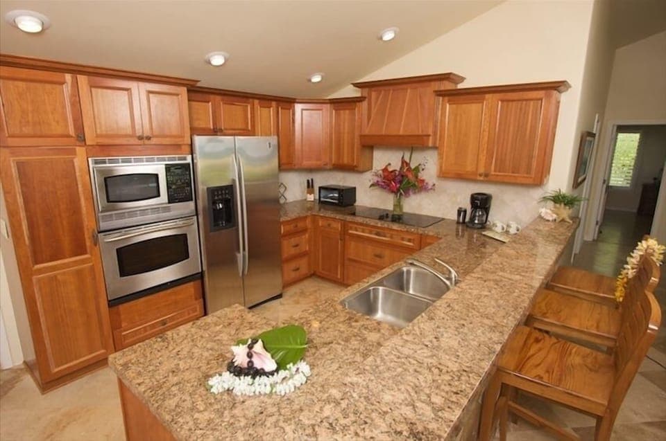 Stainless-steel kitchen with granite countertops and cherry cabinets