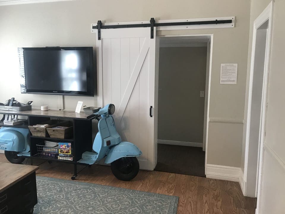 Barn door gives some privacy to bedroom in Suite 2. Door on right is bathroom.