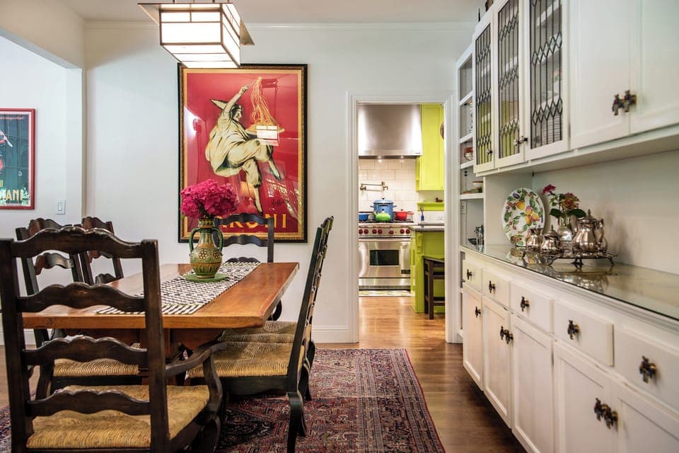 The all-white farmhouse-style DR contrasts with the striking kitchen colors