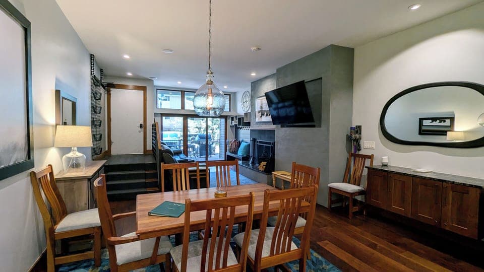 Living room with dining table, wood fireplace, and patio w/ propane BBQ grill