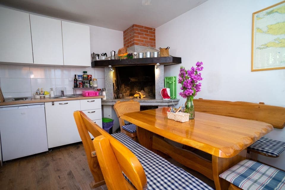 the house has a summer kitchen with a big breakfast table, a coffee machine, BBQ